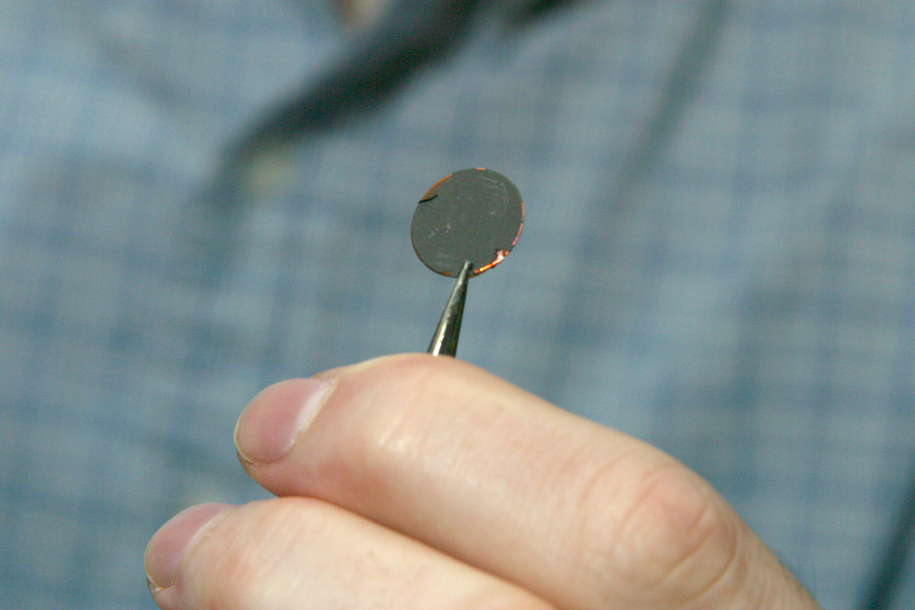 A researcher at Sandia National Laboratories holding a silicon-graphite composite battery electrode